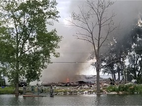 Smoke rises from a post-explosion fire at a house on Marentette Beach near Point Pelee National Park Sunday, July 12, 2020. The bodies of two people were found in the lower level after the fire was put out. The Ontario fire marshal is investigating. (Dave Tesolin/Special to Postmedia)