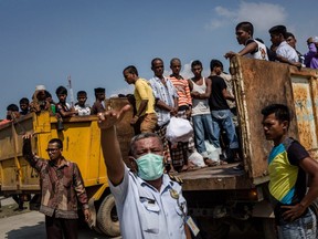Rohingya and Bangladesh migrants board on to a truck as relocated to their new temporary shelter  (Photo by Ulet Ifansasti/Getty Images file photo)