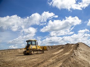 A bulldozer moves earth under the heavens during construction of Phase Four of the Summerside subdivision at the corner of Bradley Avenue and Chelton Road in London. Derek Ruttan/The London Free Press/Postmedia Network