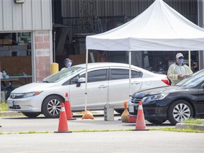 Medical professionals assess people in their cars at the Carling Heights Optimist Community Centre COVID-19 assessment centre in London, Ont. on Monday July 27, 2020. (Derek Ruttan/The London Free Press)