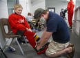 Andrew Farrow ties the skates of his son Carter, 9, at the Western Fair Sports Centre in London on Friday July 31, 2020. Carter was participating in a Total Package Hockey skills camp. Camps are limited to 12 players and three instructors because of COVID-19. (Derek Ruttan/The London Free Press)