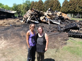 Lauren Edwards, left, founder of Charlotte's Freedom Farm, and Christine Rettig, who rescued 35 animals, stand in front of a barn that was destroyed in a fire at the Brook Line facility near Chatham just before midnight Wednesday. (Ellwood Shreve/Postmedia Network)