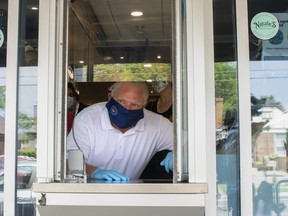 Ontario Premier Doug Ford stands at a window used for take-outs, as he visits a bakery in Toronto, on Friday, July 10, 2020. (THE CANADIAN PRESS/Chris Young)