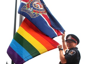 Former London diversity officer Const. Theresa Allot raises the rainbow flag at the Dundas Street police headquarters. (Free Press file photo)