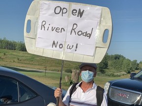 Hans Reimer brought a protest sign, and his clubs, to the shuttered River Road golf course on Saturday. Photo taken July 18, 2020. (Norman De Bono/The London Free Press)