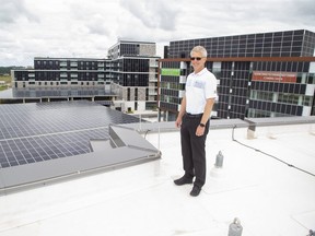 Richard Sifton, president and CEO of Sifton Properties, stands on the roof of the company's head office Monday, July 13, 2020, in the West 5 neighbourhood the company constructed in London, Ont. Behind him are two parkades with solar panelled roofs, Helio (the most energy efficient apartment complex in Canada) and and a solar panel covered office building. (Derek Ruttan/The London Free Press)