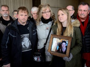 Dave and Shauna Andrews and their daughter, Sara, hold photos of their son. Cody Andrews. who was killed by an impaired driver in a London crash in 2016. (Files)