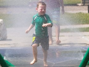 Thomas Doggart, 4, runs through the rinse cycle at the splash pad in Gibbons Park in London, Ont. on Monday June 29, 2020. (Mike Hensen/The London Free Press)