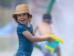 Kaya Shepard, 4, of London, takes her bucket to be filled at the Gibbons Park splash pad. (Mike Hensen/The London Free Press)