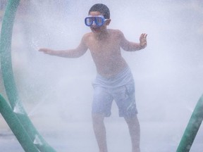 Ali Kirtay, 8 of London  wears a swimming mask as he plays at the Gibbons Park splash pad. His dad, Mustafa Kirtay, said the family needed some fresh air as they arrived at the park. (Mike Hensen/The London Free Press)