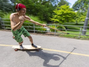 You've heard of paddle boarding, well Matt Mullenix of London uses a stick to propel him down the multi-use pathways near the King Street bridge in London, Ont. on Tuesday, July 14, 2020.  (Mike Hensen/The London Free Press)