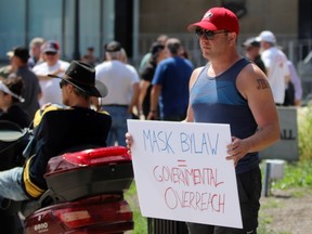 A person who declined to be identified holds up a sign during a protest against Sarnia's mandatory mask bylaw on Thursday July 30, 2020. (Terry Bridge/Sarnia Observer)