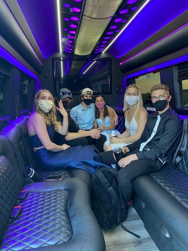 Teens wear their masks while getting ready for a celebration inside a Wave Limousine vehicle.