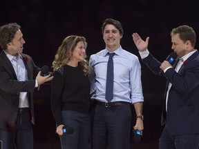 Co-founders Craig Kielburger, left, and Marc Kielburger introduce Prime Minister Justin Trudeau and his wife Sophie Gregoire-Trudeau as they appear at the WE Day celebrations in Ottawa, Nov. 10, 2015.