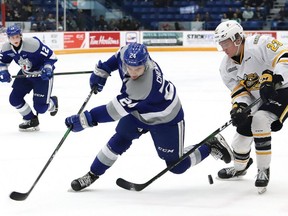 Brad Chenier, left, of the Sudbury Wolves, and Joseph Mack, of the Sarnia Sting, battle for the puck during OHL action at the Sudbury Community Arena in Sudbury, Ont. on Friday February 14, 2020. (John Lappa/Postmedia Network)