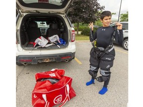 Callum Antunes, 12, of Glencoe, dons his goalie gear in the parking lot of London's Western Fair Sports Centre before a Future Pro hockey lesson on Tuesday, August 4. (Mike Hensen/The London Free Press)