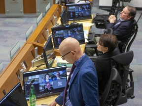 Councillors Michael van Holst (standing), Maureen Cassidy and Paul Van Meerbergen were seated at desks normally reserved for city staff to allow safe distancing of councillors around the horsehoe during a council meeting at city hall in London, Ont. on Tuesday March 24, 2020. Five members of council, Anna Hopkins, Steve Hillier, Josh Morgan, Steve Lehman and Mayor Ed Holder participated through video conference. Derek Ruttan/The London Free Press/Postmedia Network