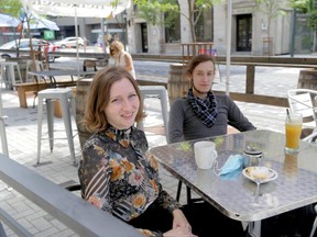 Kaz Adams, left, and Nikita Leshakov enjoy The Scot's Corner patio on Dundas Street in London. (Derek Ruttan/The London Free Press)