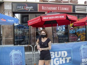 Bartender Sonja McKerracher wears a mask outside Fitzray's at Dundas and Talbot streets. Bylaw officers said there were no pandemic-related  infractions over the holiday weekend. (Derek Ruttan/The London Free Press)