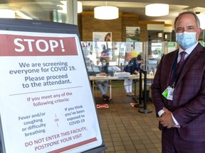 Roy Butler, the VP of patient care and risk management for St. Joseph's Health Care in London, Ont. stands at the entrance to Parkwood Hospital where COVID-19 screeners are set to guide patients for in-person appointments. (Mike Hensen/The London Free Press)