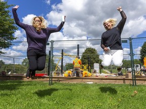 Principal Dawn Ruddick and vice-principal Tara MacDonald of Lord Elgin Public School in London jump for joy as workers install new playground equipment, something the low-income school hasn't had for several years. It was purchased with money from a GoFundMe campaign that was supercharged by the generosity of LFP readers this spring.  Photograph taken on Monday August 31, 2020. (Mike Hensen/The London Free Press)