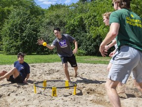 Tiger McDonald of Pickering goes in for a slam as George Barrie of Vancouver is out of the play during a game of spike ball at Western University on Monday.  McDonald's partner Simon Hawke (partial hidden) waits as Matthew Bell of Toronto looks to return the ball in a game that is similar to volleyball. (Mike Hensen/The London Free Press)