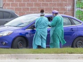 Health care workers assess a person at the Carling Heights Optimist Community Centre COVID-19 assessment centre  in London, Ont. on Monday May 4, 2020. (Derek Ruttan/The London Free Press)