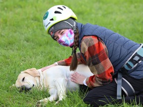 Laurentian University student Maggie Ryan visits with a nearby dog, Cedar, during an outdoor class in Sudbury on Friday September 18, 2020. John Lappa/Sudbury Star/Postmedia Network