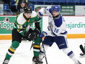 Owen Robinson, right, of the Sudbury Wolves, and Hunter Skinner, of the London Knights, battle for the puck during OHL action at the Sudbury Community Arena in Sudbury, Ont. on Friday December 20, 2019. (John Lappa/Postmedia Network)