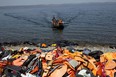 In this file photo taken on September 10, 2015, migrants arrive on the shores of the Greek island of Lesbos after crossing the Aegean Sea from Turkey on a dinghy.(Photo by ANGELOS TZORTZINIS/AFP via Getty Images)