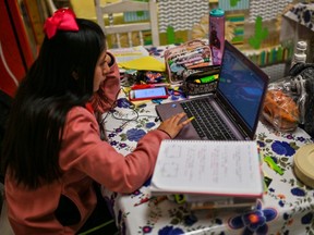 Secondary student Diana Thaili takes a class at her mother's restaurant in Mexico. In London, online classes start Wednesday for Thames Valley Distric school board students and Friday for students of the Catholic board. (Photo by PEDRO PARDO/AFP via Getty Images)