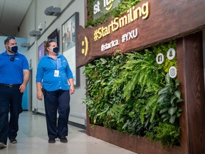 Lance Sierolawski and Jen Wheatley of London International Airport survey a new "living wall" of plants in the terminal The three-metre-high wall, contributed by Start.ca., features an assortment of plants and mosses native to Ontario. (Max Martin, The London Free Press)