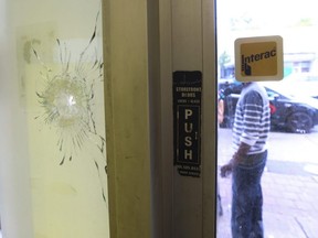 Ivoran Anson stands outside Spence's Bakery in front of bullet holes that ripped into a restaurant during an early morning shooting in Toronto, Wednesday Sept. 2, 2020.