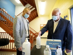 Ontario Premier Doug Ford, right, uses hand sanitizer as he gets a tour of Kensington Community School from principal Dan Fisher to see the safety measures implemented as students return to school amidst the COVID-19 pandemic on Tuesday. A letter writer praises the wor of Ford and his "tireless team" during this pandemic. (Carlos Osorio/The Canadian Press)