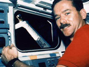 Astronaut Chris Hadfield demonstrates a model of the robotic arm to be installed on the International Space Station