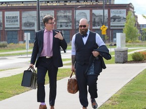 Phillip Millar, left, and Nick Cake, lawyers for St. Thomas police Const. Steve Cudney, leave the St. Thomas police station after the first day of Cudney's Police Services Act hearing on Sept. 14, 2020. (Files)