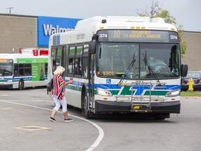 A woman boards a London Transit bus at White Oaks Mall in London. Bus service is back to near-normal levels, but rider numbers are barely half what they were prior to the pandemic. (Derek Ruttan/The London Free Press)