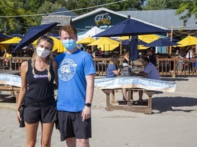 Lindsay Kenny and Jack Dunn are servers at GT's On The Beach. The Port Stanley restaurant was permitted to expand its patio onto the beach, allowing it to operate this summer at about 70 per cent of its usual capacity. (Derek Ruttan/The London Free Press)