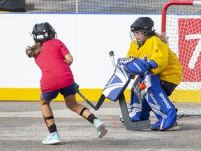 Ilderton Jets goalie Teagan Brooks makes a save on Kaylee  Masse of The Bad Girls in their U9 semi-final game at the HockeyFest road hockey tournament in London on Sunday. Fifteen portable rinks were erected in the parking lot of Westmount mall, with 150 teams participating. Derek Ruttan/The London Free Press