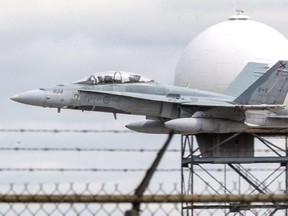 An RCAF CF-18 fighter from 3 Wing Bagotville in Quebec makes several low passes over the runway at London International Airport Thursday, Sept. 10, thrilling onlookers ahead of Airshow London thi9s weekend. (Mike Hensen/The London Free Press)