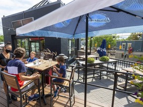 Server Neisa Long takes an order from Finn Chaix, dining with his sons Finn, 9, and Milo, 6, on the rooftop patio at Jack Astor's on Richmond Street in London.  (Mike Hensen/The London Free Press)