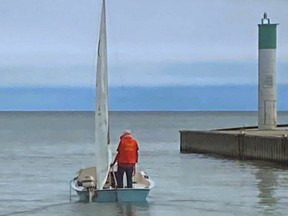 Reginald Fisher of Dutton, who vanished Thursday after his small sailboat capsized on Lake Erie, is seen on the 14-foot craft in the Port Glasgow harbour earlier this month in an image taken by a restaurant worker there. Police say the 77-year-old, the search for whom was called off Monday, was not an experienced sailor. 
(Supplied photo)