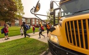 Students at Lord Nelson public school in London hop off the bus Monday to attend class. (Mike Hensen/The London Free Press)