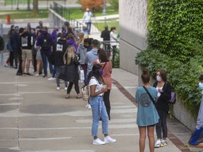 A long line of Western  University students waits to be assessed at the on-campus COVID-19 assessment centre, which opened at 11 a.m. Monday. By noon, officials said it had reached its daily capacity of 220 tests. Many of those left waiting were given a red ticket to come back at another time Monday, or told to return Tuesday. (Mike Hensen/The London Free Press)