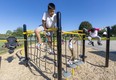 William Moo, 10, of Lord Elgin Public School climbs a rope wall, part of the new playground equipment installed at the school. Mike Hensen/The London Free Press