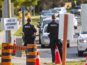 London Police officers wait at the entrance to the Oakridge arena COVID-19 assessment centre on Monday, Sept. 28, to tell drivers they can only get in with an appointment ticket.
The centre ran out of appointments before 8:30 a.m. (Mike Hensen/The London Free Press)