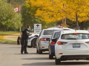 Police officers stop motorists entering the Carling Optimist COVID-19 assessment centre to make sure they have appointments or turning them away as the centre reached capacity soon after opening in London, Ont.  Photograph taken on Monday September 28, 2020. (Mike Hensen/The London Free Press)