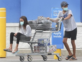 Masked shoppers exit the east Windsor Walmart store.