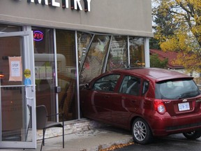 No one was hurt Thursday morning after a small red vehicle crashed into the front windows of an optometry in London's Old South. (JONATHAN JUHA/The London Free Press)