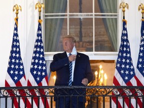 U.S. President Donald Trump removes his mask upon return to the White House from Walter Reed National Military Medical Center on October 05, 2020 in Washington, DC. Trump spent three days hospitalized for coronavirus. (Photo by Win McNamee/Getty Images)